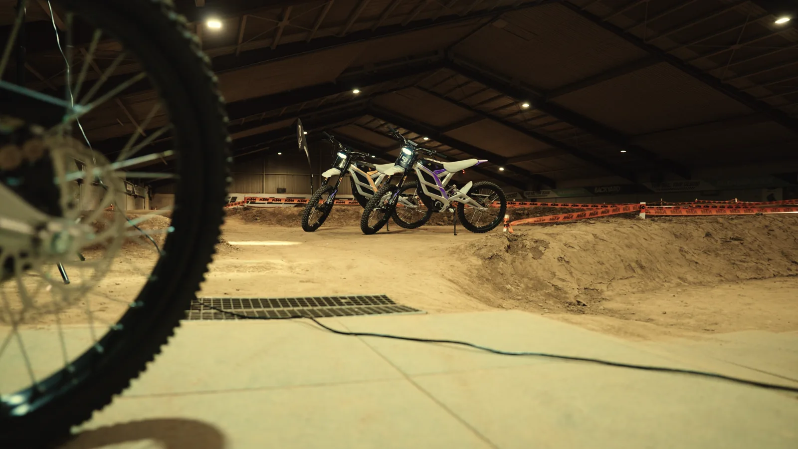 Leichte 79er-Bikes am Rand der Indoor-Motocross-Strecke der eDirtarena