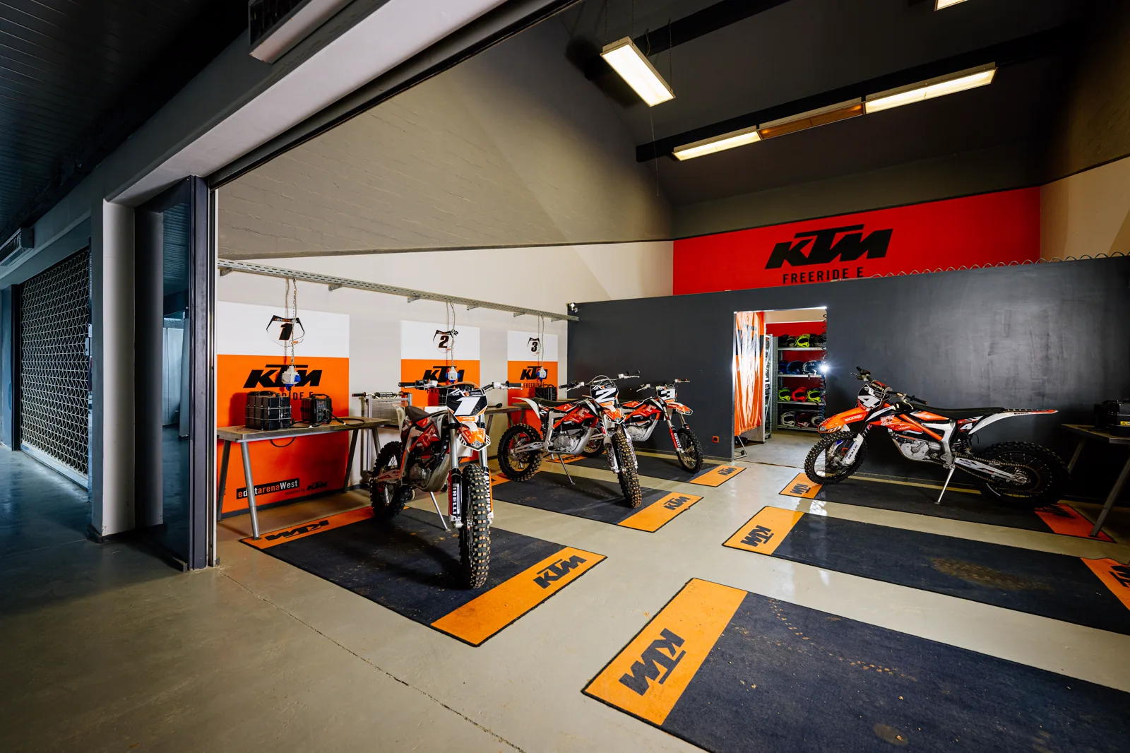 Offener E-Hangar der eDirtarena mit vorbereiteten Elektro-Motocross-Motorrädern
