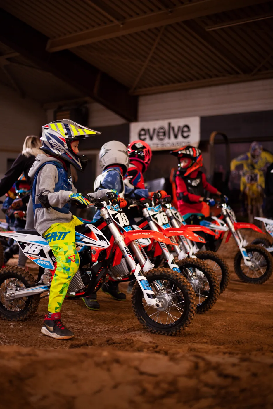 Gruppe von Kindern mit ihren Elektro-Motorrädern am Start der Indoor-Strecke