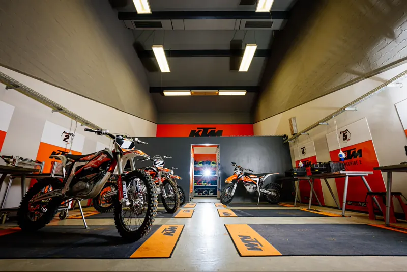 Leihmotorräder der eDirtarena aufgereiht in der KTM-Werkstatt
