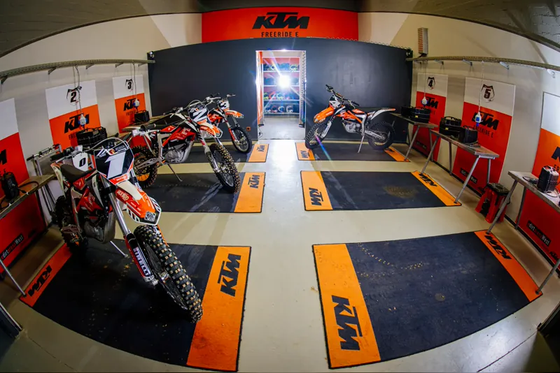 Weitwinkelaufnahme der KTM-Werkstatt der eDirtarena mit mehreren Motocross-Motorrädern