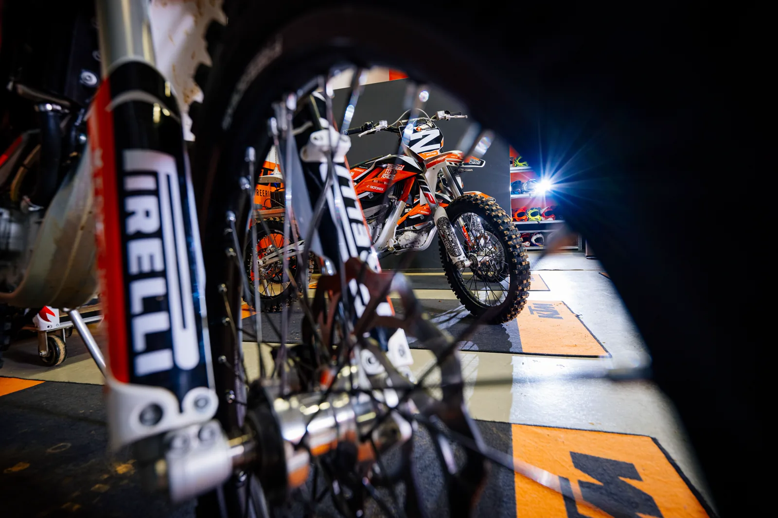 Elektro-Motocross-Motorrad der eDirtarena in der Boxengasse, Detailaufnahme von Vorderrad und Reifen