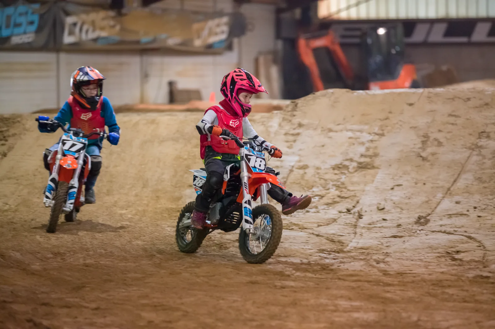 Zwei Kinder üben das Fahren auf der Indoor-Motocross-Strecke der eDirtarena